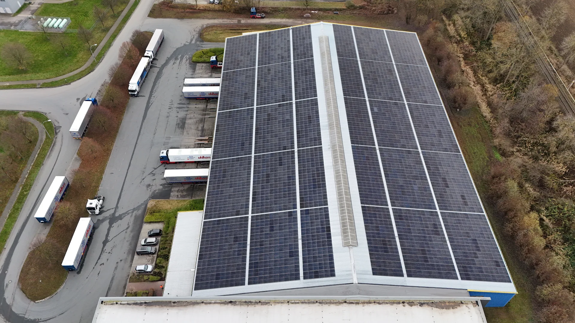 Vogelperspektive von Nordwesten: vollständig bestücktes Hallendach mit aktivem LKW-Betrieb am Ladebereich